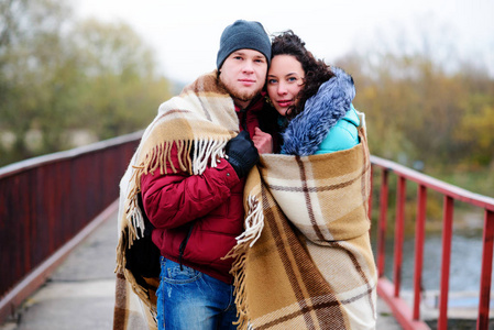 年轻夫妇拥抱，站在桥上，布满了普拉伊