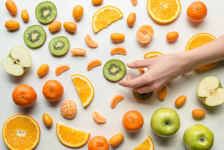 女性手上的柑橘类水果白色背景顶部视图
