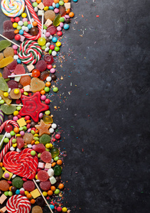 五颜六色的糖果。棒糖, 杏仁, 棉花糖, 果酱和糖果。带空间的顶部视图, 供您问候