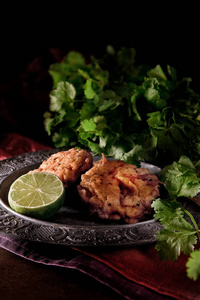 正宗餐厅风格素食真正的印度洋葱 Bhajis 开胃菜, 拍摄反对黑暗背景与香菜 香菜 背景与绿色石灰。复制空间