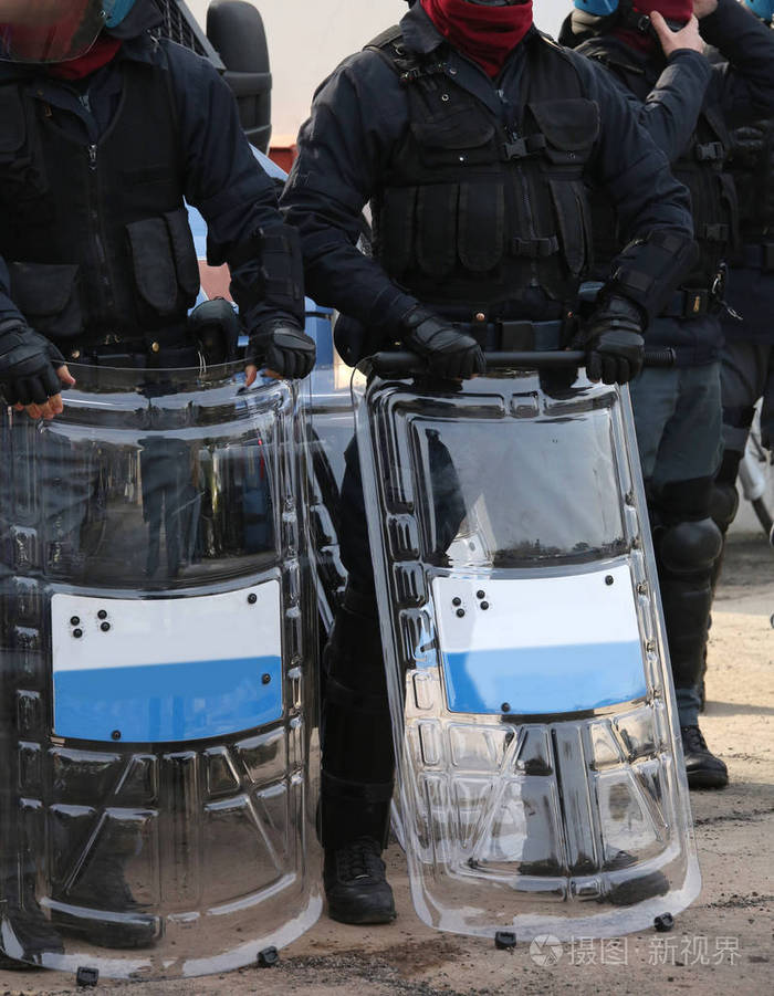 在赛事期间齿轮用盾牌和防暴警察