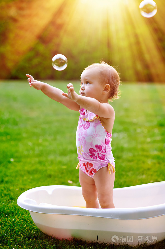 漂亮的小女孩在夏天洗澡用肥皂泡