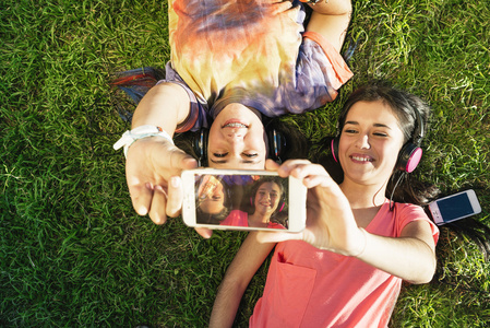 两个十几岁的女孩在公园中采取自拍照