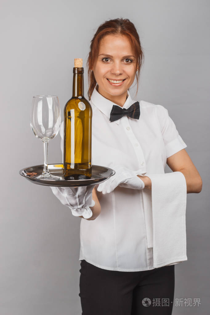 女服务员用一瓶酒和酒杯