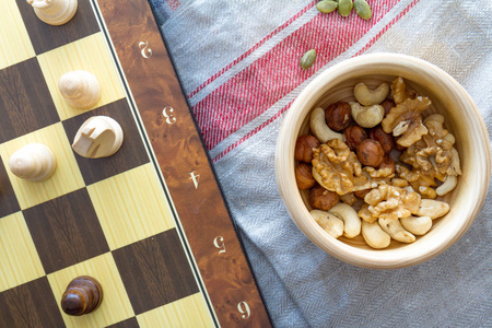 健康饮食观念。干果和坚果混合在平方策略游戏桌上的棋片