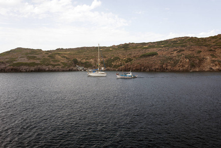 夏季希腊帕特莫斯岛爱琴海的海滩岩石和充气小船的景色