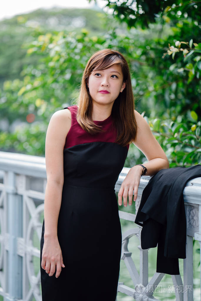 一个美丽的亚洲女商人的肖像在公园的礼服亚洲商业妇女站在城市