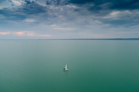 白色帆船在巴拉顿湖湖与云彩天空
