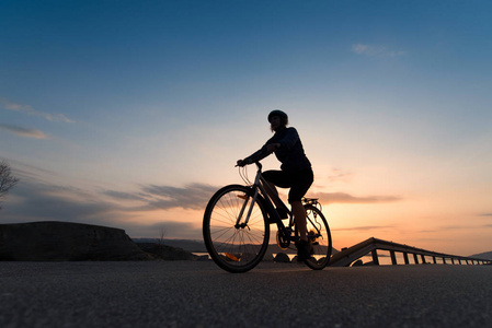 在日出的骑车人的低角度看。体育和活跃生活概念在夏天时间