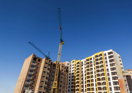 起重机和高层建筑在建设蓝天的映衬下