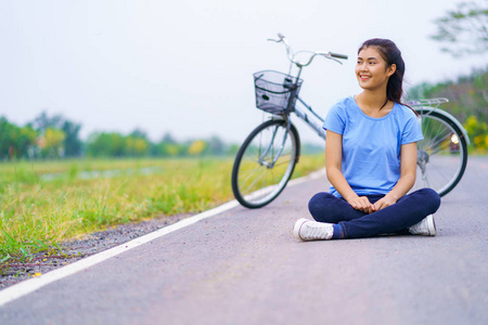 女孩与自行车, 妇女坐在路在公园和自行车