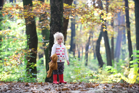 秋天森林里的小女孩.孩子与泰迪熊在童话森林.