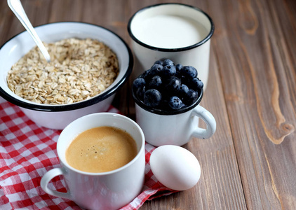 健康的早餐是一个伟大的开始新的一天。燕麦粥, 咖啡, 浆果和坚果在一张木桌上。特写