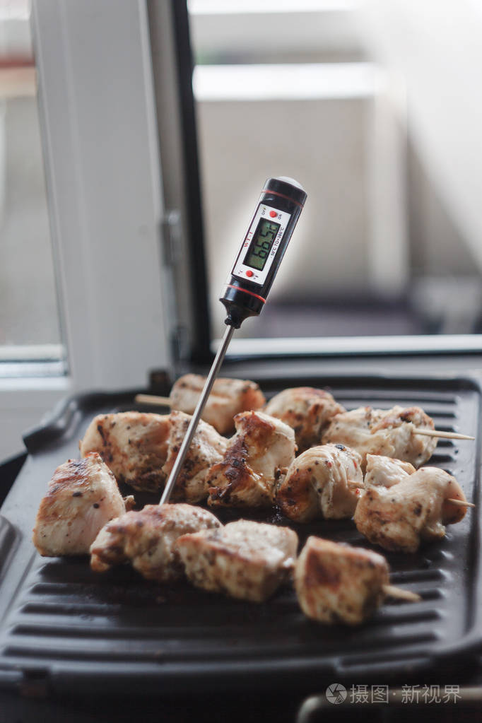 猪肉牛肉羊肉串烤肉串准备在家庭电动烧烤。测定肉类准备和温度的温度计