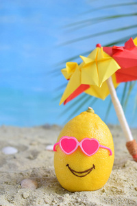 创意极小的夏日创意。柠檬柑橘时髦的太阳镜和沙滩伞上的沙子。热带海滩概念。创意艺术。复制空间
