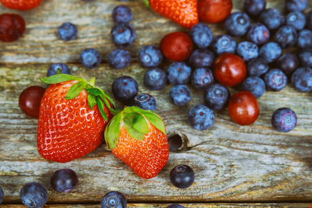 健康的吃夏天草莓, 蓝莓在木桌背景