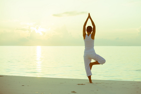 练瑜伽在海滨的白种女人