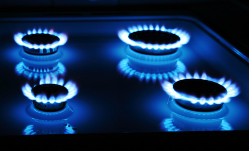 蓝色燃气灶在黑暗中与四个圆环的火焰