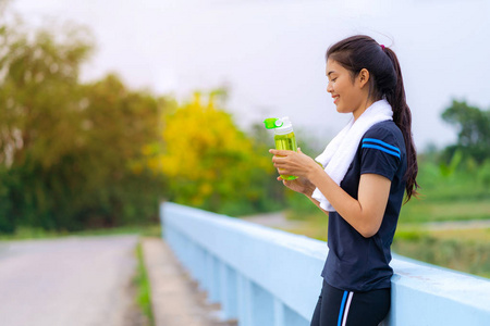 一个美丽的女孩在运动装与一瓶水分的肖像