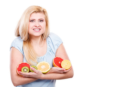 健康的饮食，刷新富含维生素的食物。快乐积极微笑的女人拿着水果猕猴桃。橙 柠檬和葡萄柚