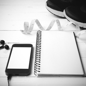 测量磁带 笔记本和手机黑色和白色的跑步鞋