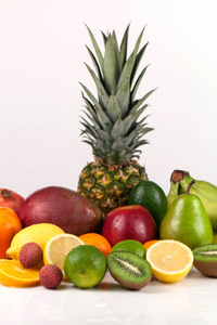 各种各样的热带水果。在白色背景上的多汁 有色人种和成熟水果。垂直的工作室拍摄