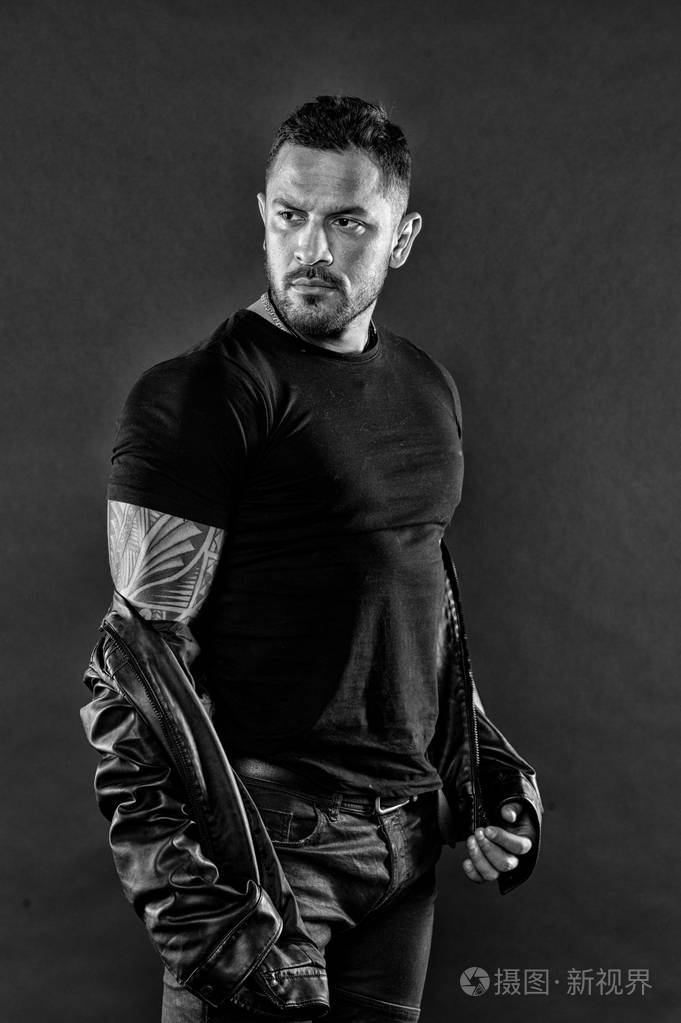 阳刚之力和力量.大胡子男子在强壮的手臂上显示纹身.