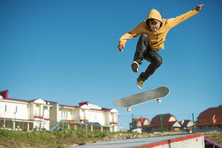 一个少年滑板并在郊区的城市滑板翻转技巧