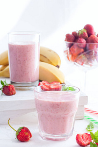 草莓和香蕉的冰沙在白色桌上的玻璃杯, 选择性聚焦