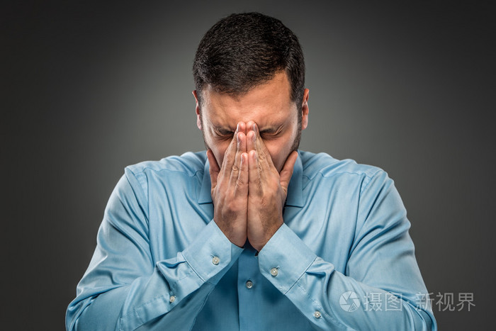 愁眉苦脸的人用手捂住脸
