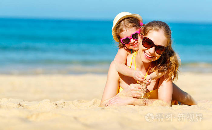 快乐家庭的母亲和孩子女儿夏天在海滩上