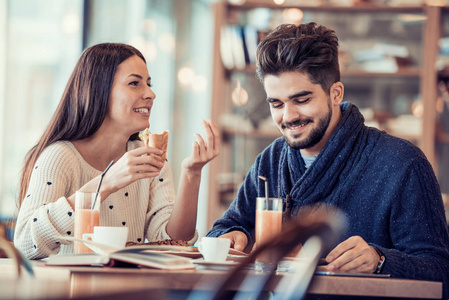 快乐的年轻夫妇，在咖啡厅吃早餐