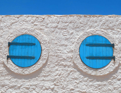 在地中海地区的一个村庄, 在白宫的一个圆圈形状的两个蓝色窗口