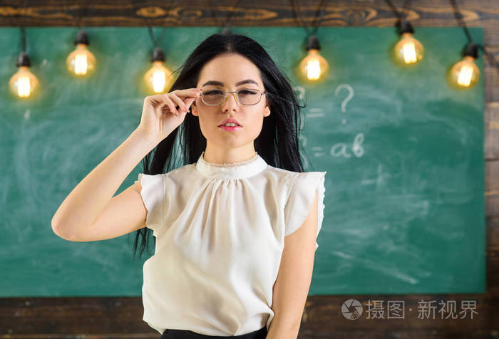严格的教师理念.夫人严厉的老师在镇静面孔站立在黑板前面