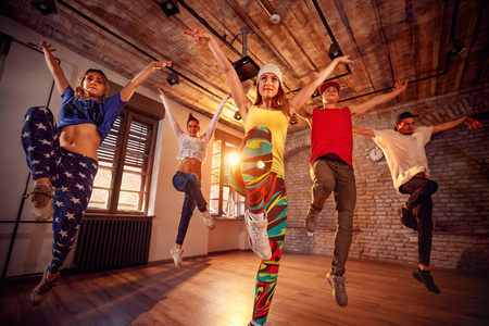 青年现代舞舞蹈团在跳跃中练习跳舞。体育舞蹈与城市文化理念