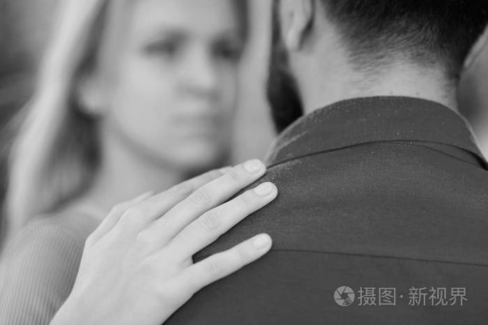 男人作为对女人的支持和保护女孩拥抱胡子的人把手放在他的肩膀上