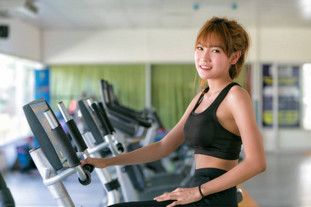 亚洲年轻女人在运动磨损里健身房做运动