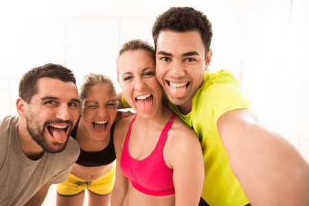 年轻的运动人群组成与智能手机的拍照在健身房