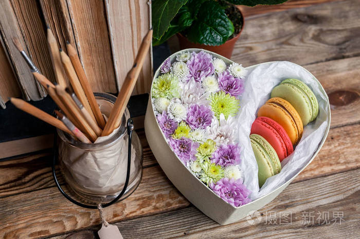 礼品盒中有一颗心形的花和杏仁的田园背景.糖果和花卉概念