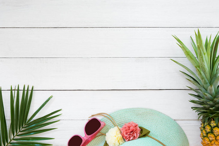 热带水果的概念。菠萝, 草帽, 太阳镜和棕榈树枝上的木板白色的颜色。暑期背景和顶级景观设计