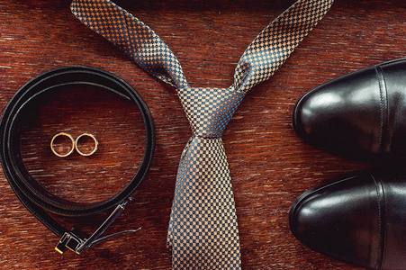 现代新郎配件的特写。结婚戒指 领带 皮鞋和皮带