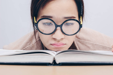 西瓜又大又圆与老又大又圆的眼镜的书呆子年轻的亚洲女学生厌烦读书