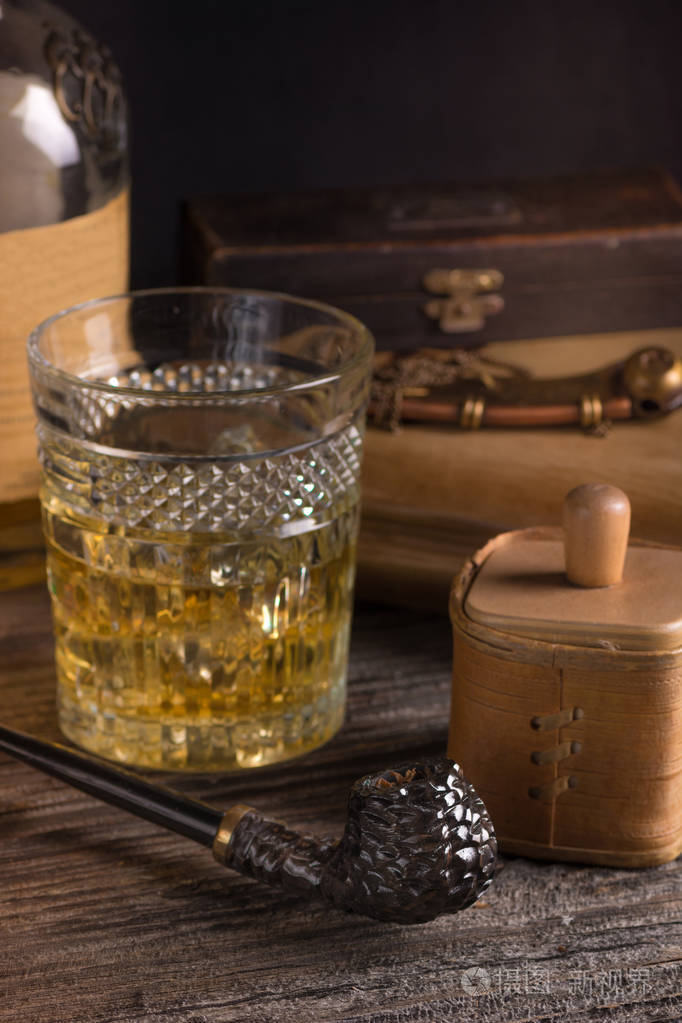 烟草在木桌上的高高的玻璃上刻着深褐色的烟烟斗和威士忌