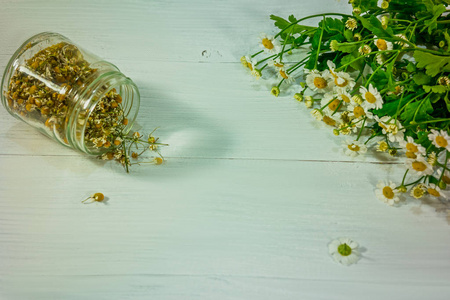 白木桌上的芳香和光疗用鲜干甘菊