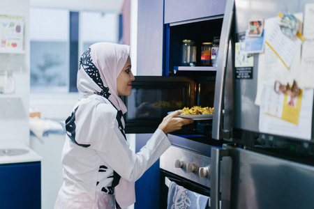 美丽的穆斯林妇女在厨房里图片