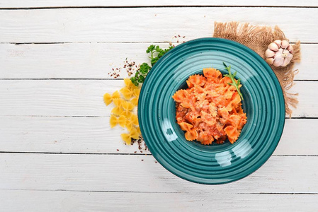 Farfalle 面食配西红柿和干酪。在一个木质的背景。意大利菜。顶部视图。复制空间