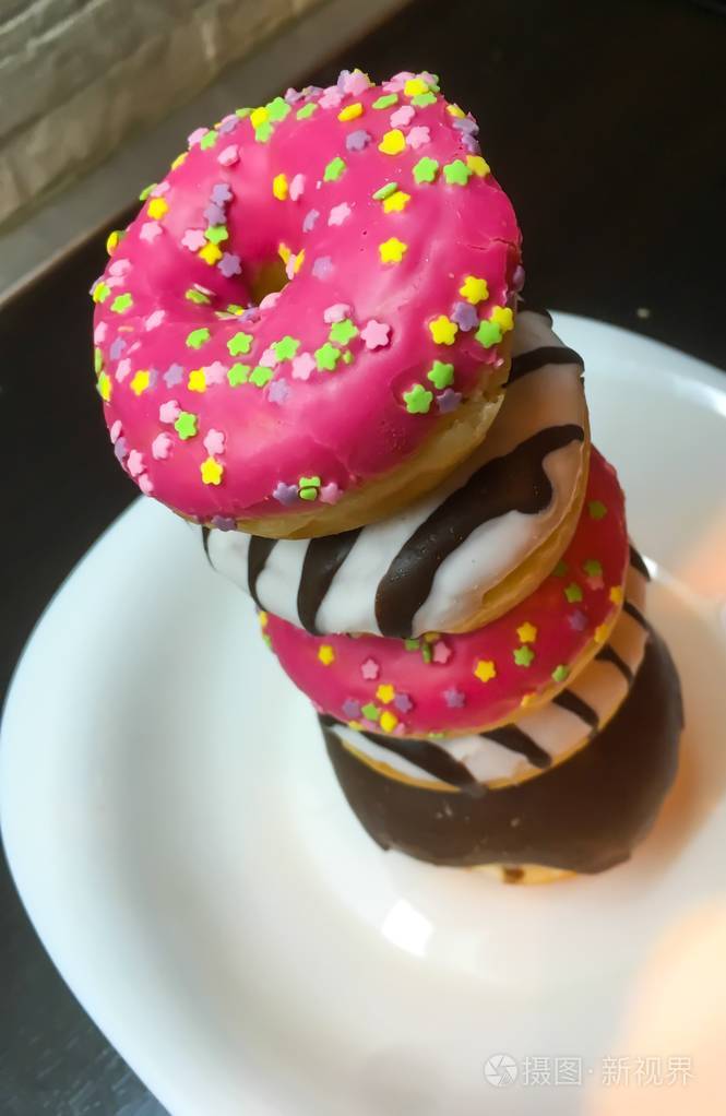 美味的粉红色甜甜圈与釉和巧克力照片特写