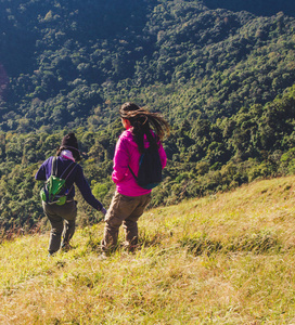 女人站着看着远方。森林和山在背景