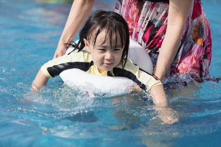 亚洲小中国女孩在游泳池室外玩耍