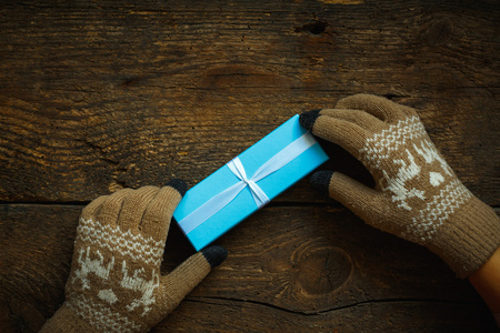 在圣诞礼品盒冬季手套的手